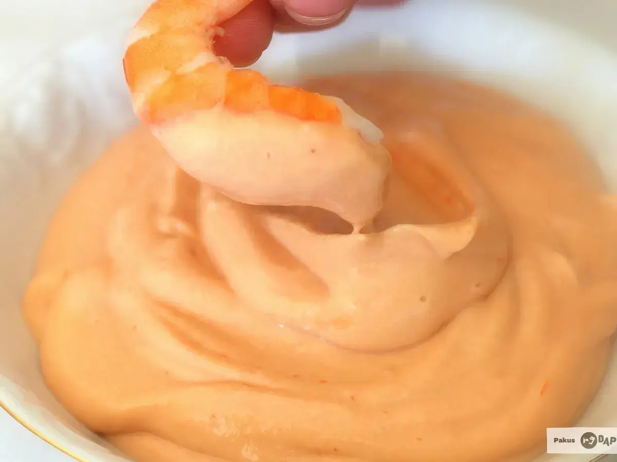 Camarón sumergiéndose en cremosa salsa rosa. ¡Un bocado perfecto!