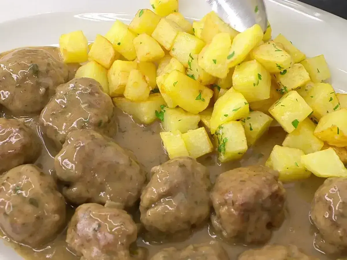 Deliciosas albóndigas en salsa con patatas fritas doradas. Una receta casera que te encantará.
