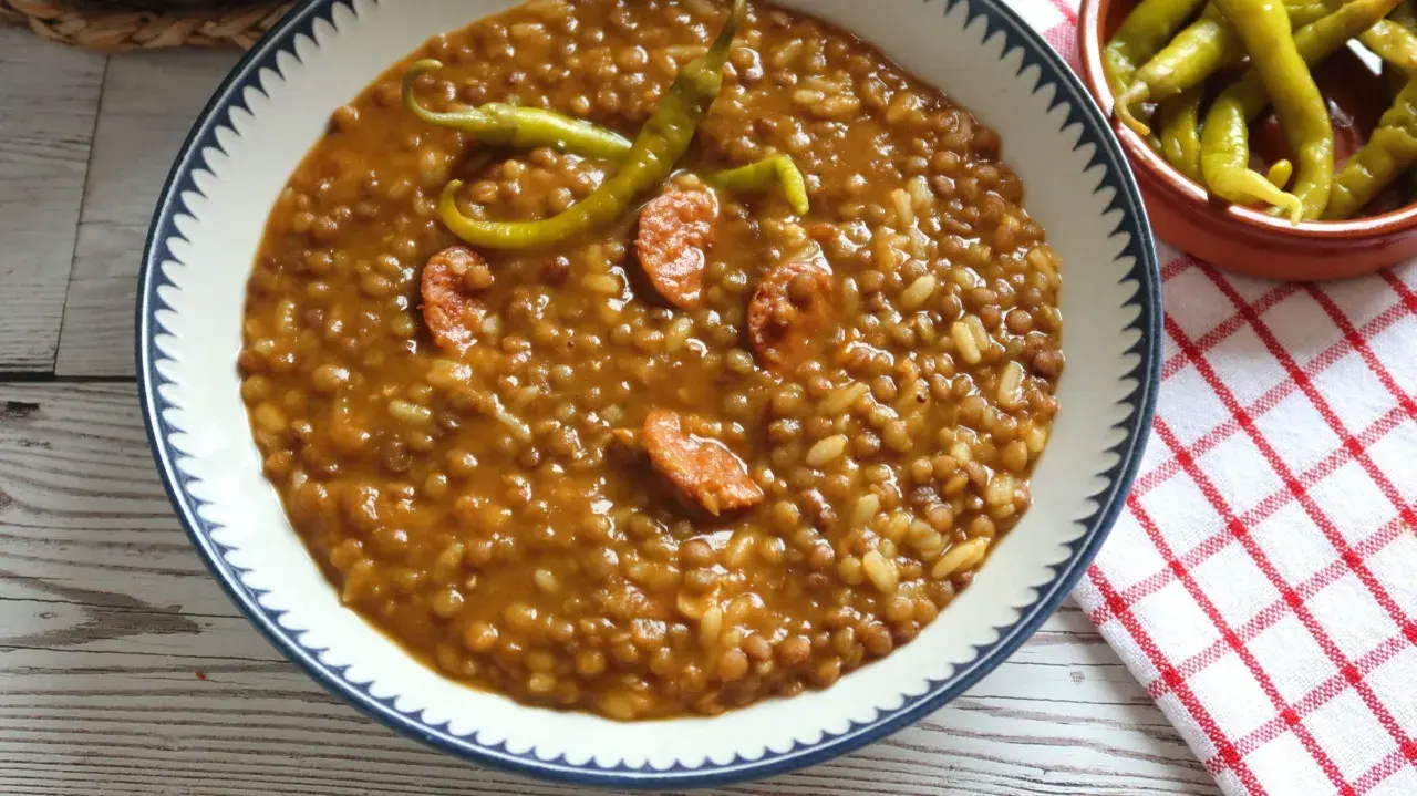 Un plato de lentejas con arroz, trozos de chorizo y guindillas verdes. Un clásico reconfortante.