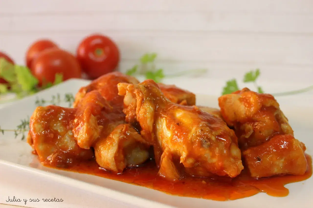 Sabroso pollo con tomate, cocinado a fuego lento hasta que esté tierno y jugoso, servido en una salsa roja vibrante.