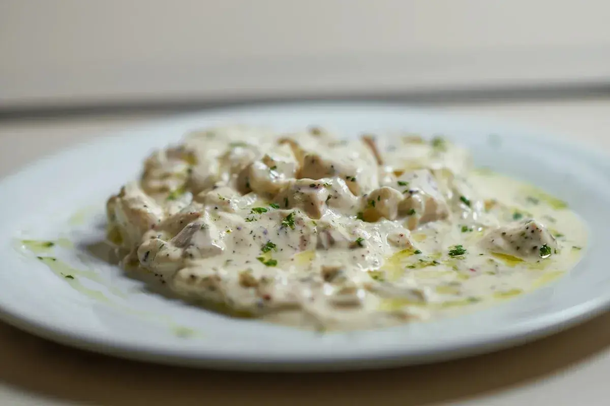 Deliciosa brandada de bacalao cremosa, con perejil picado y un toque de aceite de oliva. Un plato que invita a probar.