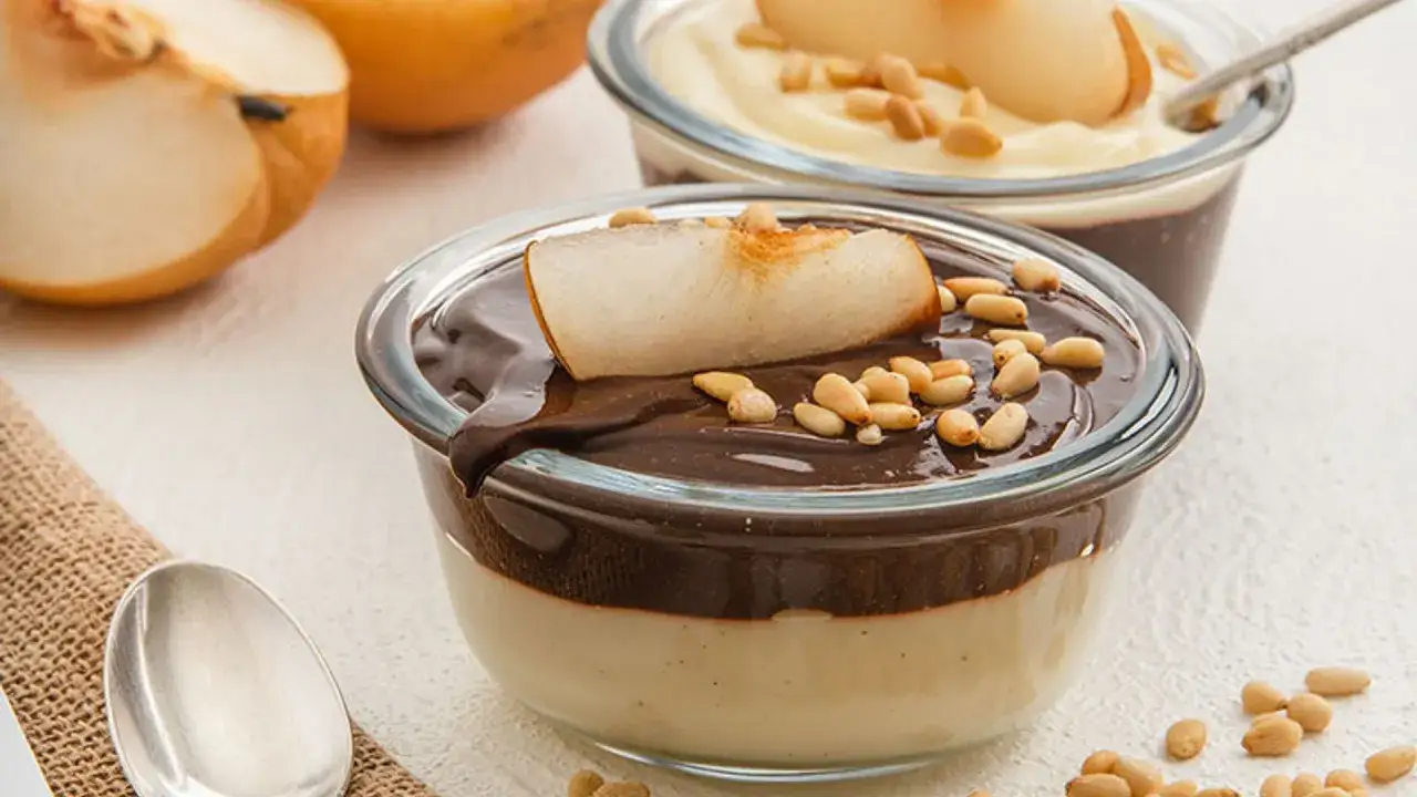 Deliciosos postres f&aacute;ciles con capas de crema y chocolate, coronados con pera y pi&ntilde;ones.