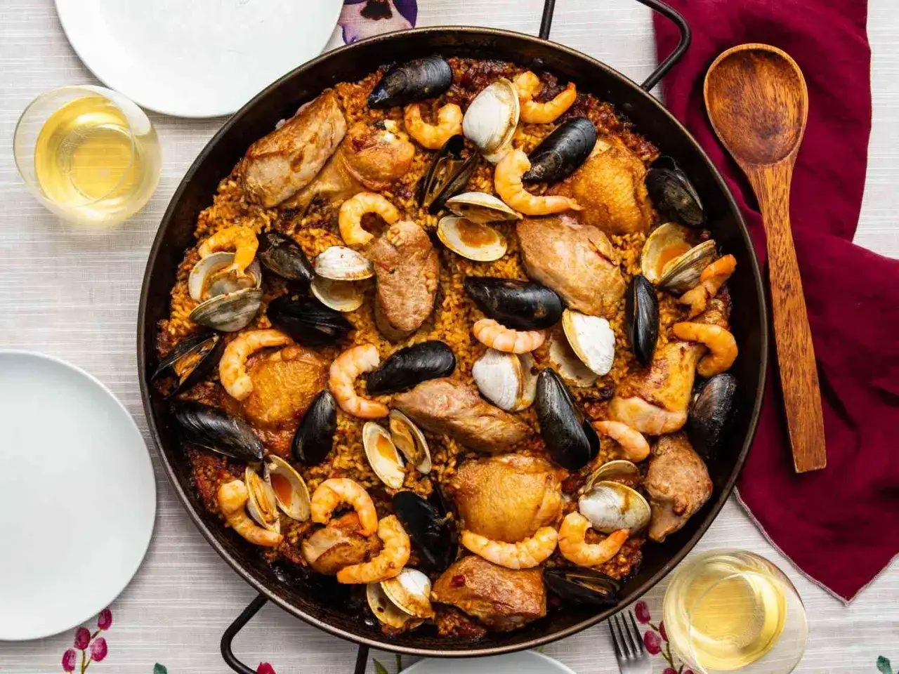 Paella mixta, un fest&iacute;n de arroz con pollo, gambas, mejillones y almejas, listo para compartir.