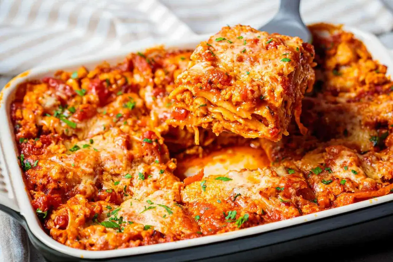 Una porci&oacute;n de lasa&ntilde;a de carne reci&eacute;n horneada, con capas de pasta, salsa de tomate y queso derretido, es servida de una bandeja.