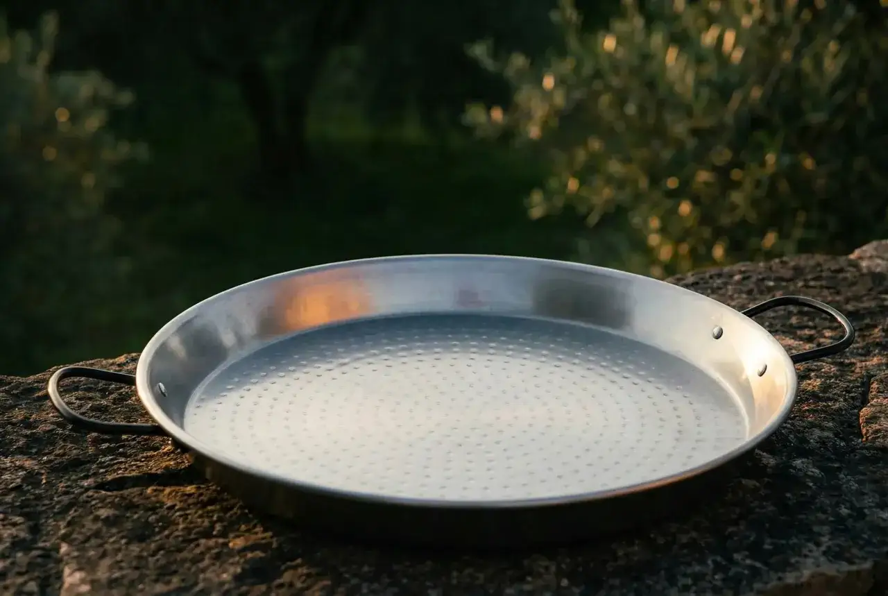 Una paellera de metal pulido, lista para preparar deliciosos arroces. Existen diversos tipos de paelleras, cada una ideal para diferentes recetas.