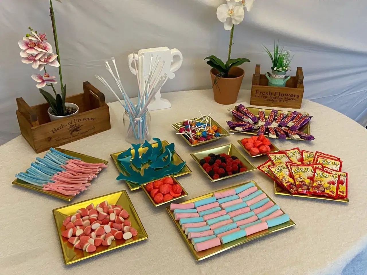 Mesa dulce con variedad de chuches: gominolas, piruletas, caramelos y fresquitos. ¡Ideas perfectas para que chuches poner en una mesa dulce!