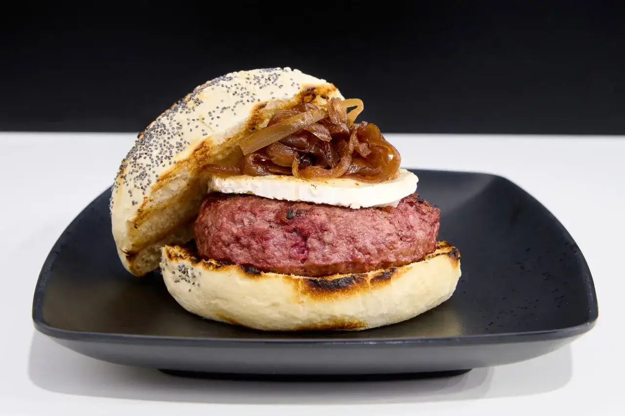 Deliciosas hamburguesas caseras con pan de amapola, queso de cabra y cebolla caramelizada.