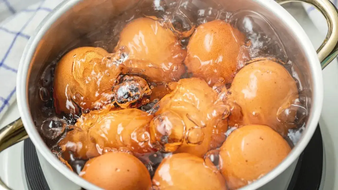 Huevos cocinándose en agua hirviendo. Si te preguntas cuanto dura un huevo cocido en la nevera, la respuesta es hasta una semana.