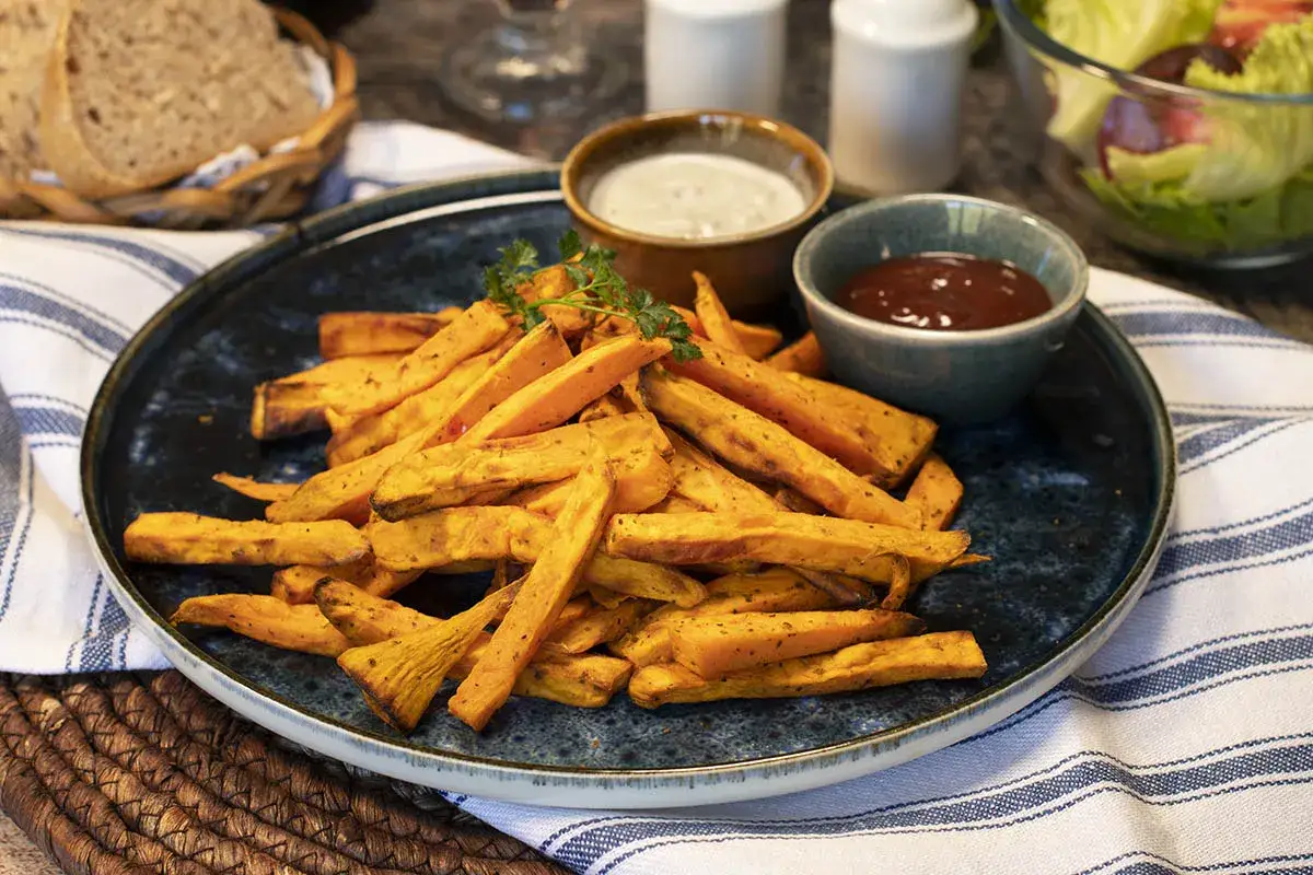 Boniato air fryer crujiente, servido con salsas y perejil.