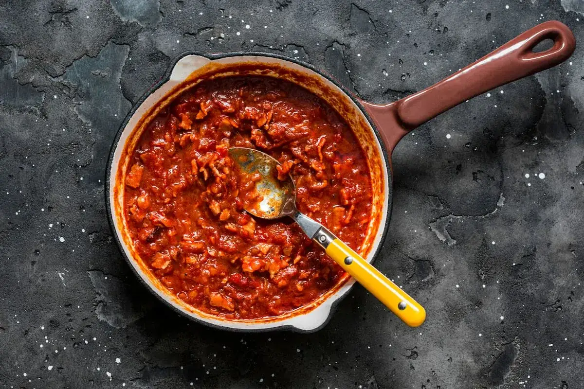 Salsa de pasta amatriciana burbujeante en una sartén, lista para ser servida.