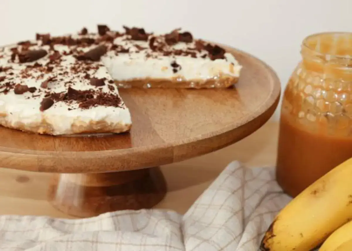 Deliciosa tarta banoffee con crema, plátano y virutas de chocolate, lista para disfrutar.