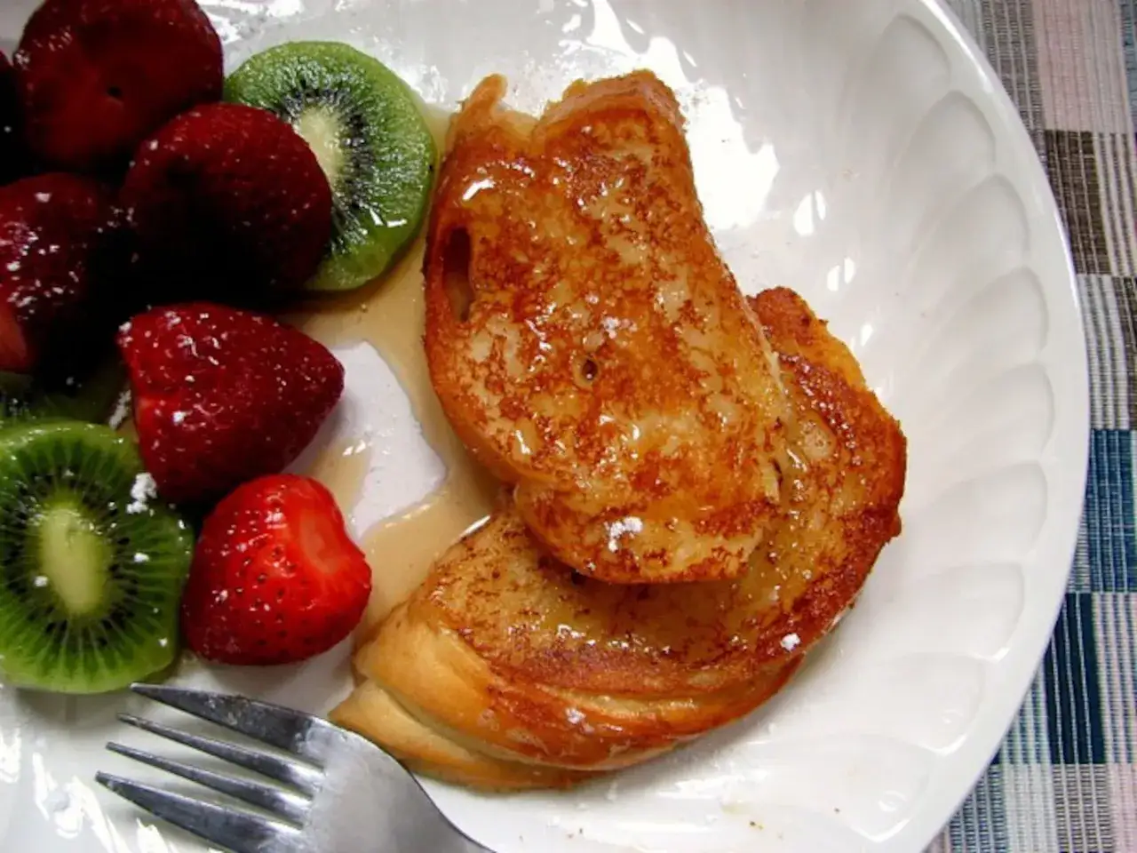 Tostadas francesas doradas y dulces, acompa&ntilde;adas de fresas y rodajas de kiwi. Un desayuno perfecto.