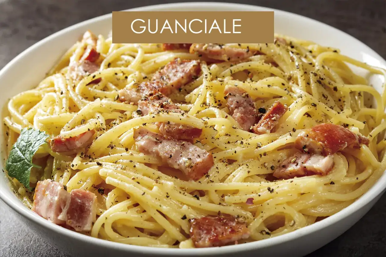 Un plato de pasta carbonara con trozos de guanciale crujiente y pimienta negra.