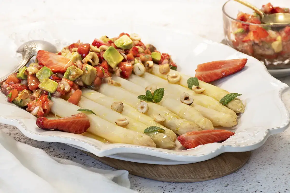 Espárragos blancos tiernos con una ensalada fresca de fresas, aguacate y avellanas. Un plato ligero y delicioso.