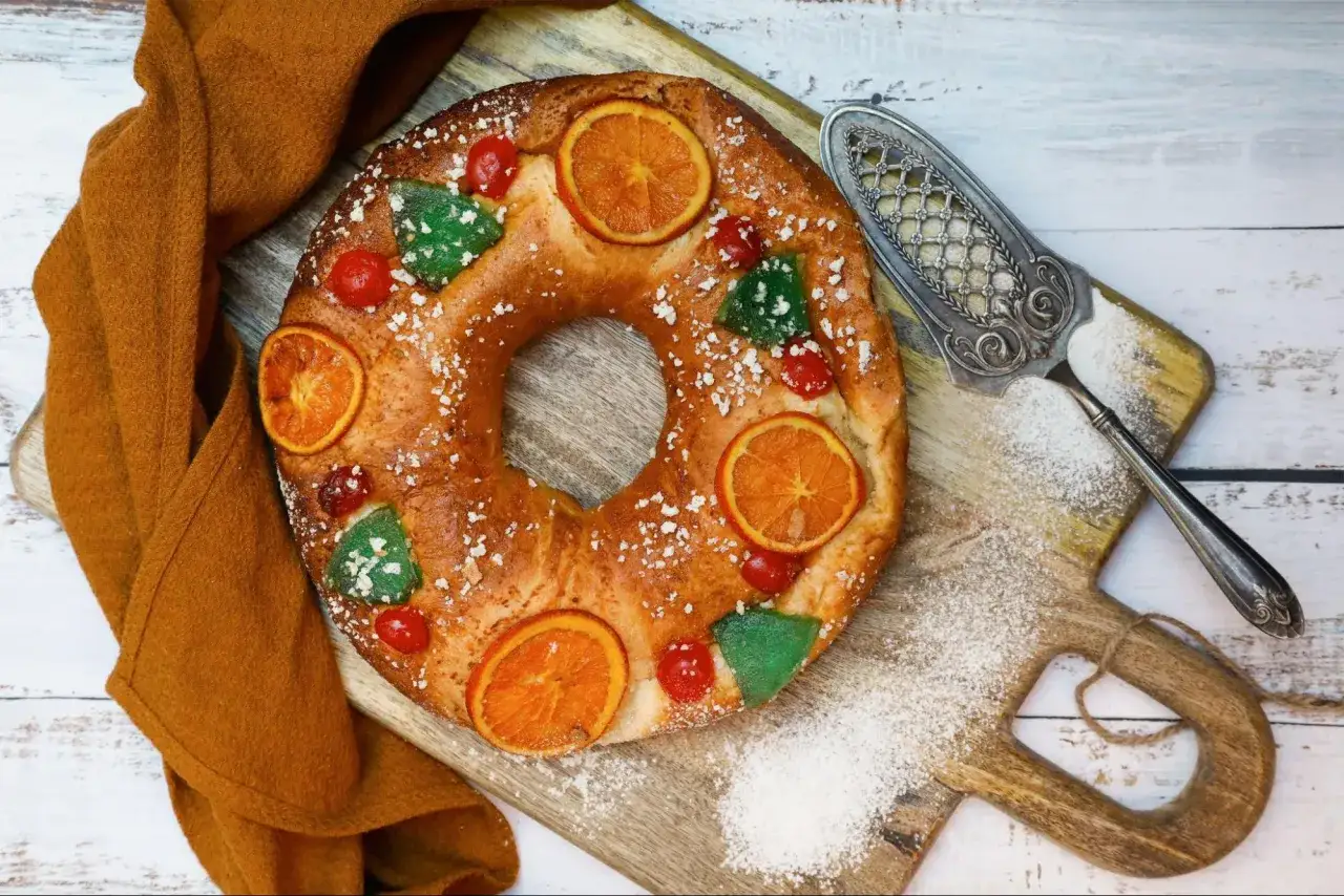 Un delicioso roscon reyes sin lactosa, decorado con naranjas confitadas, cerezas y azúcar glas. ¡Perfecto para compartir!