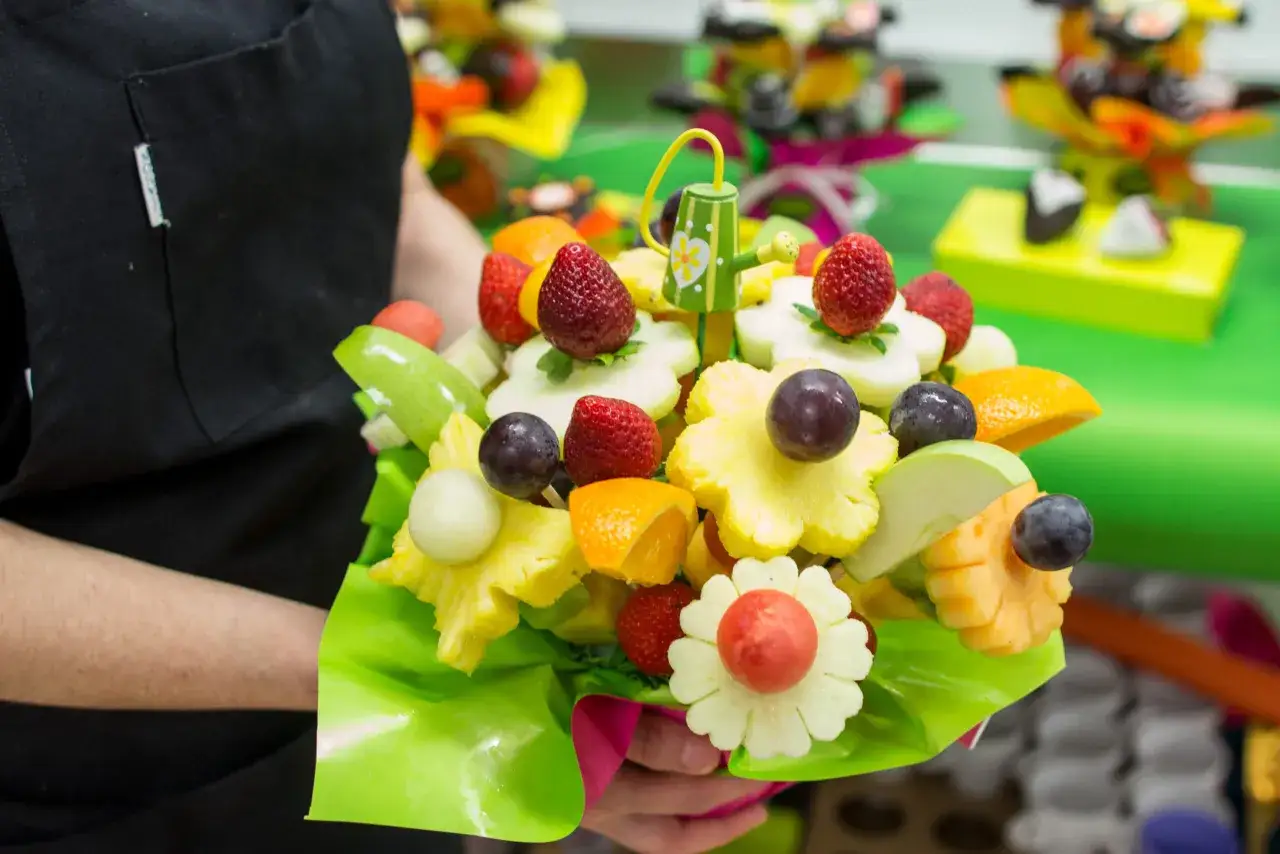 Un ramo de frutas vibrante con fresas, piña y uvas, perfecto para un cumpleaños saludable.