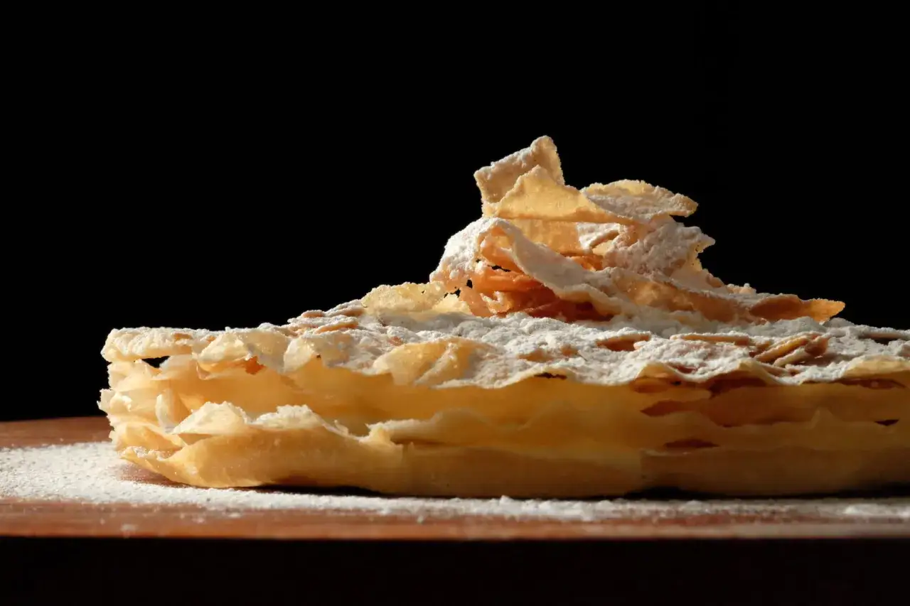 Deliciosa tarta &aacute;rabe con capas crujientes y un toque de az&uacute;car glas, lista para ser disfrutada.